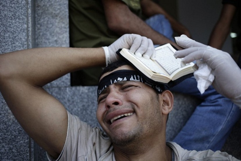 An egyptian grieves for supporter of President Mohammed Mursi, who were killed overnight clashes with security forces in Nasr City, Cairo, Saturday July 27, 2013.