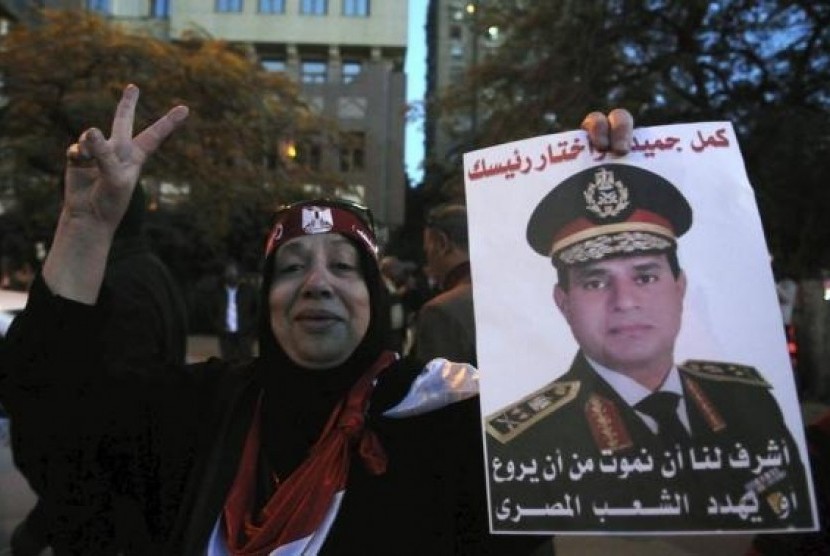 An Egyptian holds an image of Egypt's Army Chief General Abdel Fattah al-Sisi during a protest outside the Qatari Embassy in Cairo December 6, 2013.