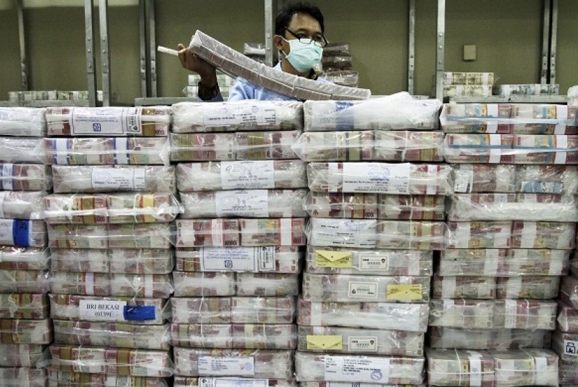 An employee of a bank stacks packets of Indonesian rupiah banknotes at a bank in Jakarta. (file photo)