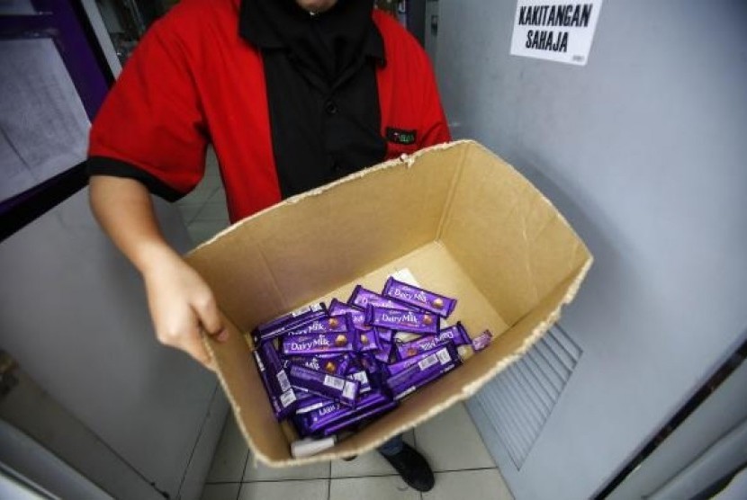 An employee shows a box containing Cadbury Dairy Milk Hazelnut and Cadbury Dairy Milk Roast Almond, to be return tomorrow in a shop in Shah Alam, outside Kuala Lumpur May 27, 2014.