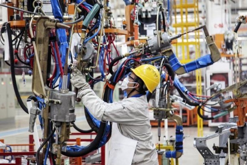 An employee works at the production line of an automobile factory in Dalian, Liaoning province, October 18, 2014.