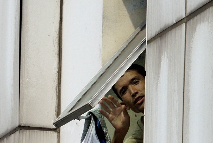 An imigrant from Afghanistan waves his hand from a window in a shelter in Tanjung Priok Jakarta, recently. (illustration)  