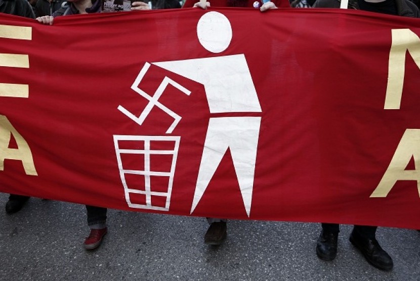 An immigrant holds a banner during an anti-racism rally in Athens January 19, 2013. 