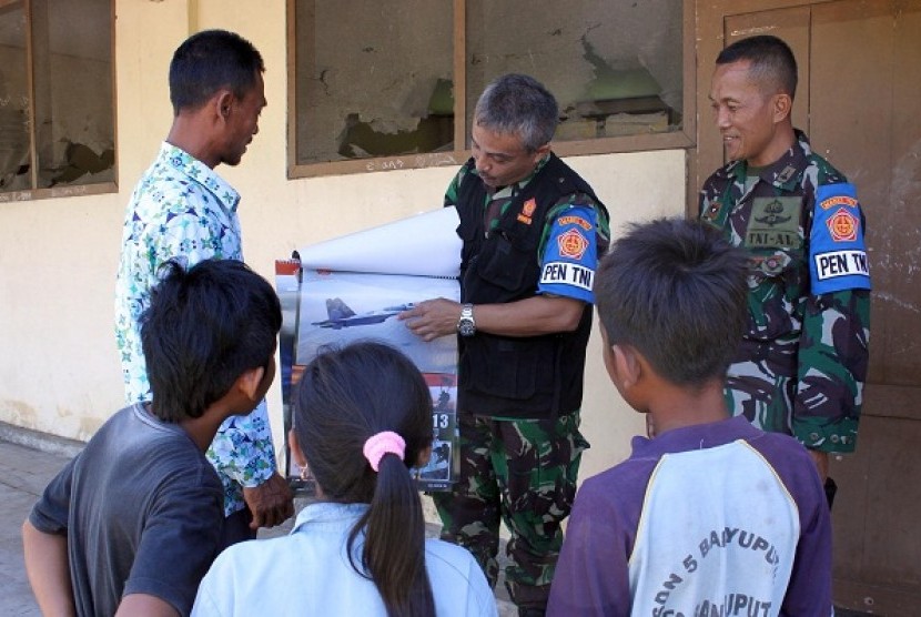 An Indonesian military officer explains about airplane to some students. In Puncak jaya, Papua, military personnel also engage in educational activities. (illustration)
