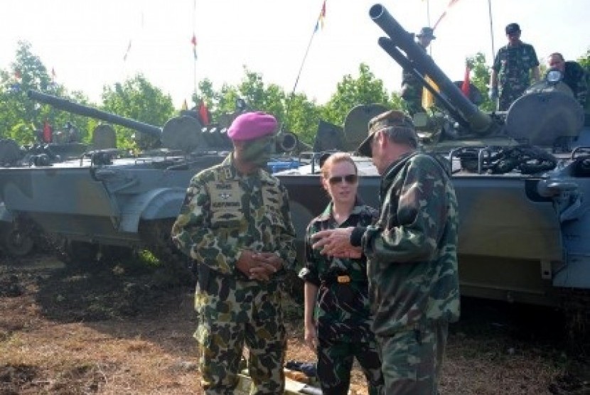 An Indonesian navy and Russian technicians have a discussion while Russian amphibious tanks park in the background in Situbondo, East Java, on Monday, Jan. 27, 2014.