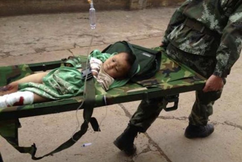 An injured child is carried by paramilitary policemen on a stretcher after an earthquake hit Longtoushan township of Ludian county, Yunnan province August 3, 2014.