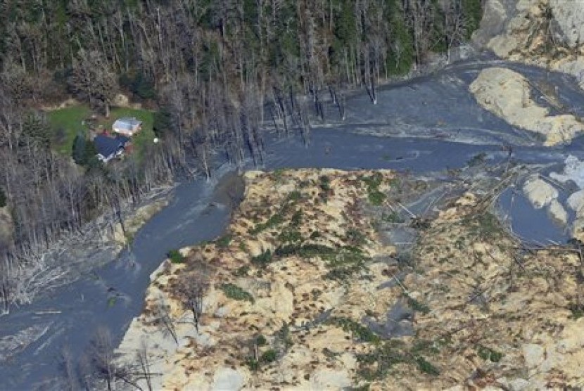 An intact house sits at left at the edge of the massive mudslide that killed at least eight people and left dozens missing is shown in this aerial photo, Monday, March 24, 2014, near Arlington, Wash. 