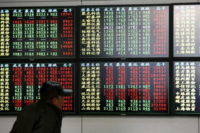  An investor looks at information displayed on an electronic screen at a brokerage house in Shanghai, December 8, 2014. 