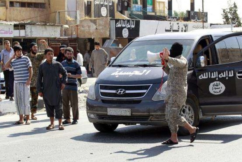 An Islamic State militant uses a loud-hailer to announce to residents of Tabqa city that Tabqa air base has fallen to Islamic State militants, in nearby Raqqa city August 24, 2014.