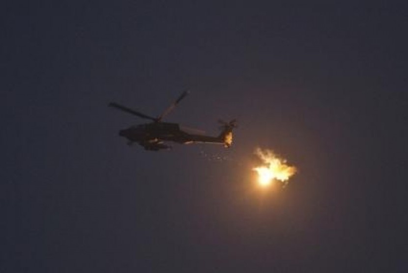 An Israeli Apache helicopter fires flares above Israel near the border with the northern Gaza Strip July 22, 2014.   