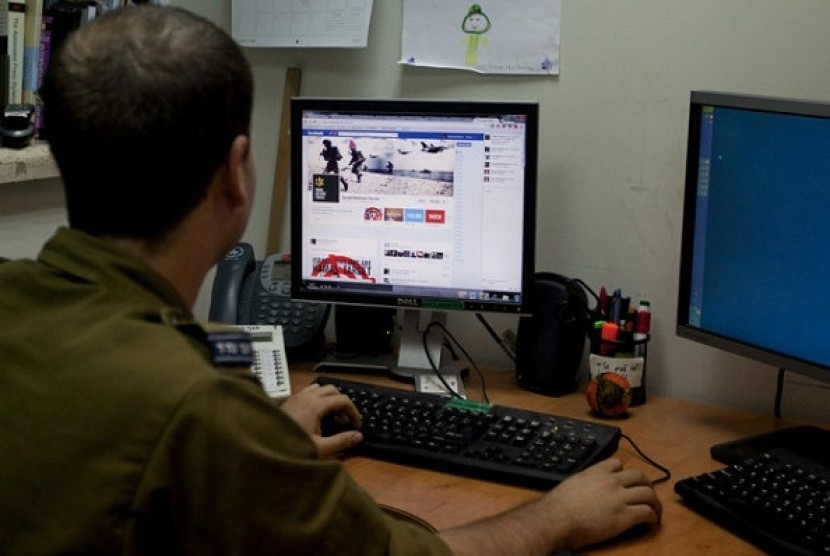 An Israeli soldier looks at the Facebook page of the Israel Defense Force, at the IDF spokesperson's office in Jerusalem on November 15. In a media bunker, attached to Israel’s press office, hundreds of volunteers work around the clock on every major socia