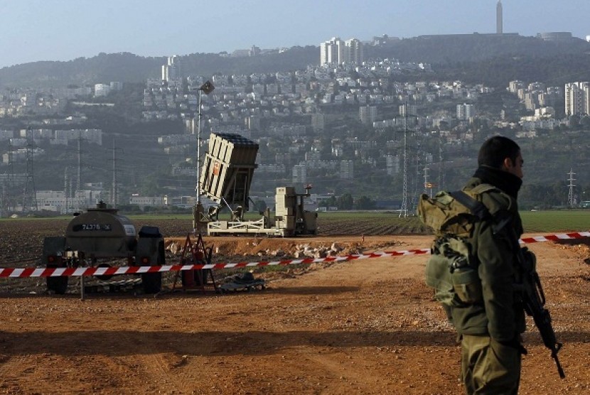 An Israeli soldier stands guard next to an Iron Dome rocket interceptor battery deployed near the northern Israeli city of Haifa January 28, 2013.