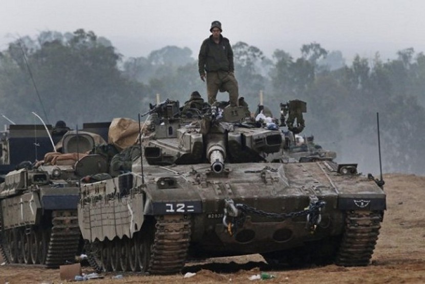 An Israeli soldier stands on a tank at a staging area near the Israel Gaza Strip Border, southern Israel, early Tuesday, Nov. 20, 2012. U.N. Secretary-General Ban Ki-moon is urging Israeli forces and Gaza militants to hold their fire, warning that a furthe