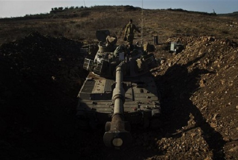 An Israeli soldier walks over a mobile artillery unit in the Golan Heights, near the border between the Israeli-controlled Golan Heights and Syria, Sunday, Sept. 1, 2013. 