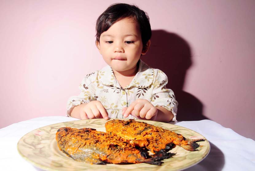 Anak makan ikan (ilustrasi). Cara sederhana untuk mengetahui pemicu alergi anak ialah dengan mencatat makanan yang dimakan dan gejala yang timbul setelah makan.