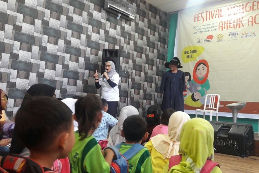 Anak-anak Aceh sedang mendengarkan dongeng yang dibawakan oleh Pendongeng dari Komunitas Ayo Dongeng Indonesia dalam rangka Roadshow Festival Dongeng Internasional Indonesia (FDII).
