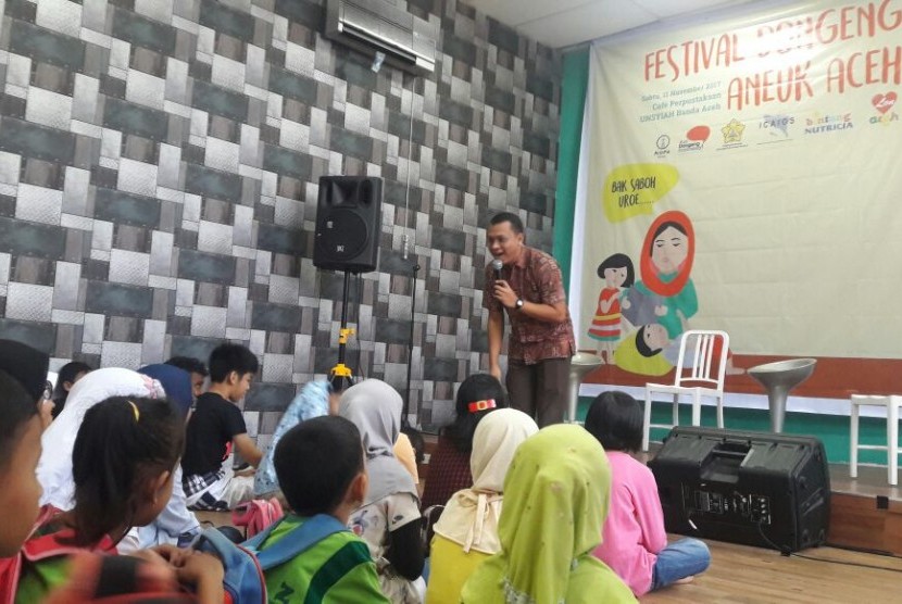 Anak-anak Aceh sedang mendengarkan dongeng yang dibawakan oleh Pendongeng dari Komunitas Ayo Dongeng Indonesia dalam rangka Roadshow Festival Dongeng Internasional Indonesia (FDII).