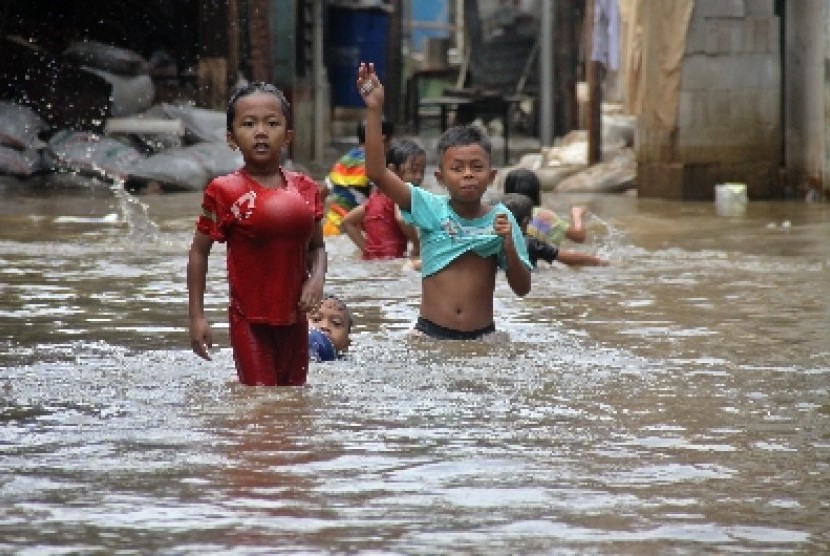 Anak-anak bermain air saat banjir melanda perkampungan di Petogogan, Jakarta Selatan