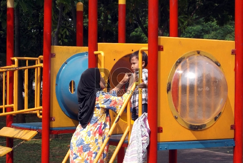 Anak-anak bermain ayunan di Taman Menteng Jakarta, Kamis (10/12).