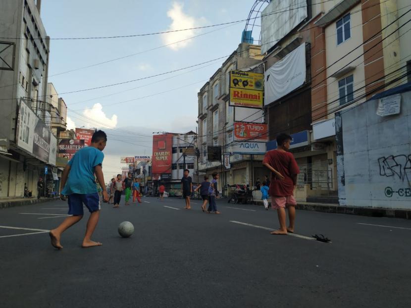 Anak-anak bermain bola di kawasan pusat pertokoan Jalan KHZ Mustofa, Kota Tasikmalaya, Rabu (21/7). Jalan itu merupakan salah satu yang ditutup oleh Satgas Penanganan Covid-19 Kota Tasikmalaya selama PPKM Darurat.