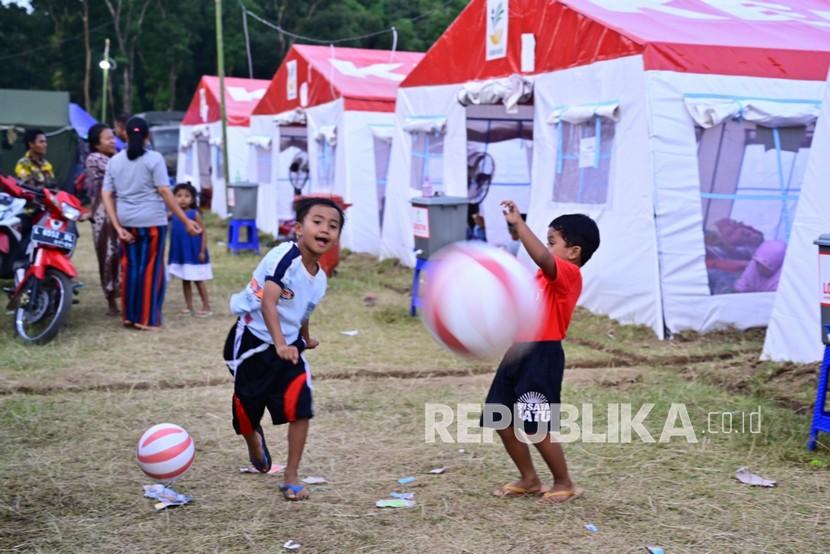 Anak-anak bermain bola di pos pengungsian erupsi Gunung Semeru di Penanggal, Candipuro, Lumajang, Jawa Timur, Sabtu (11/12/2021). Sebanyak 6.573 orang pengungsi yang tersebar di 126 titik beraktivitas di tempat pengungsian sambil menunggu proses relokasi.