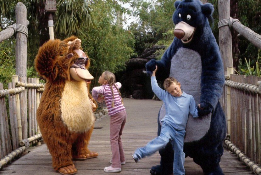 Anak-anak bermain dengan tokoh karakter di Disneyland Paris.