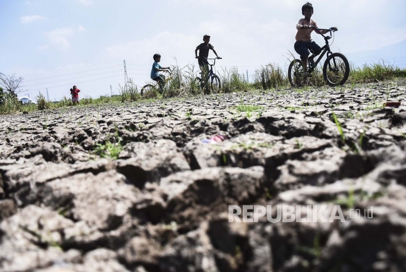Anak-anak bermain di area lahan pertanian yang mengalami kekeringan di Gedebage, Kota Bandung, Rabu (26/6).