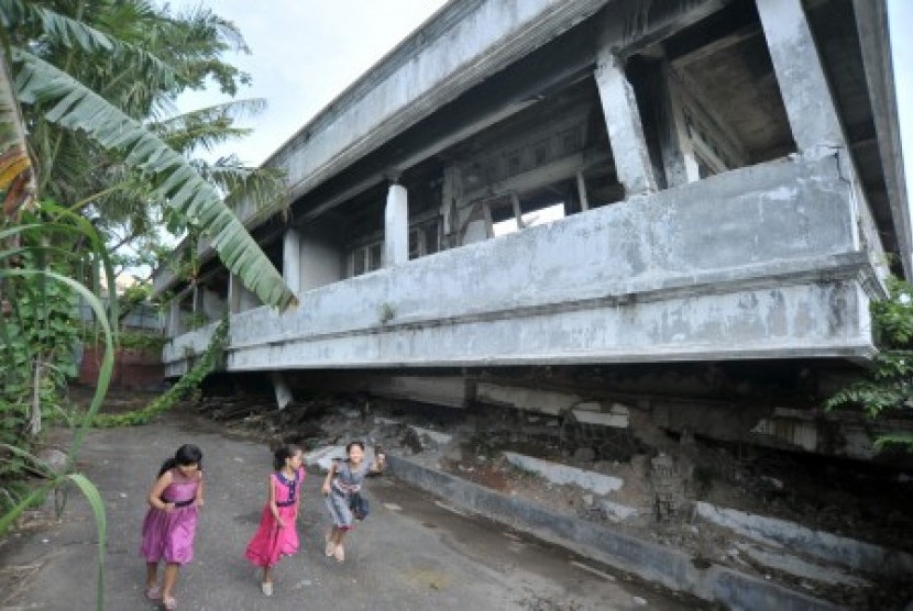 Anak-anak bermain di bangunan yang runtuh akibat gempa 30 September 2009, di kawasan gedung juang Padang, Sumatra Barat, Jumat (29/9). Delapan tahun pascagempa yang mengakibatkan sekitar seribu orang tewas tersebut digelar acara peringatan di Monumen Gempa Padang pada Sabtu (30/9). 