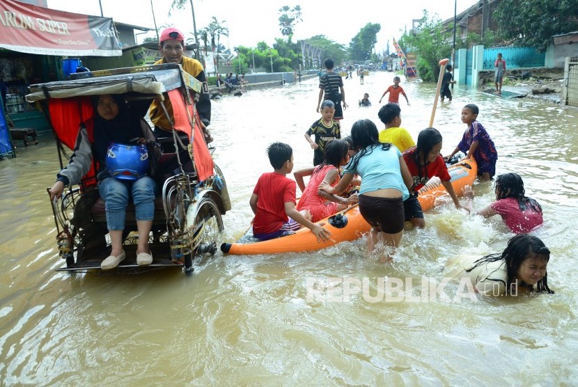 Anak-anak bermain di genangan banjir luapan Citarum, di Jalan Moh Toha, Kecamatan Dayeuhkolot, Kabupaten Bandung, Ahad (30/10). (Republika/Edi Yusuf).