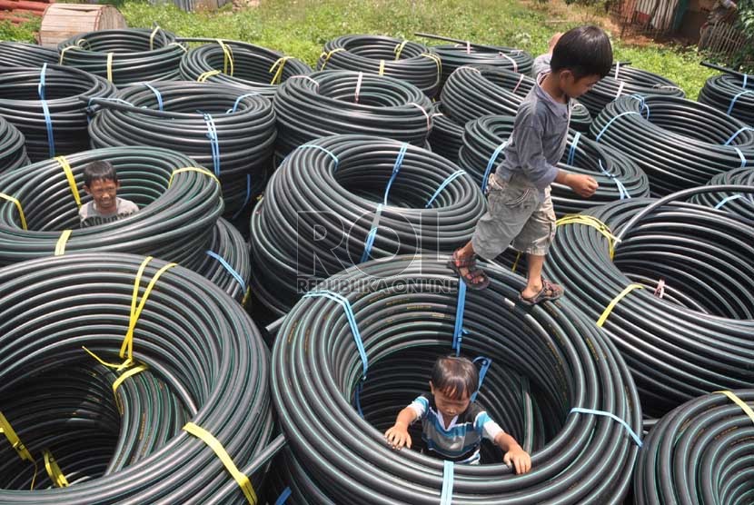   Anak-anak bermain di tumpukan gulungan pembungkus kabel di Penggilingan, Cakung, Jakarta Timur, Selasa (1/10). (Republika/Rakhmawaty La'lang)