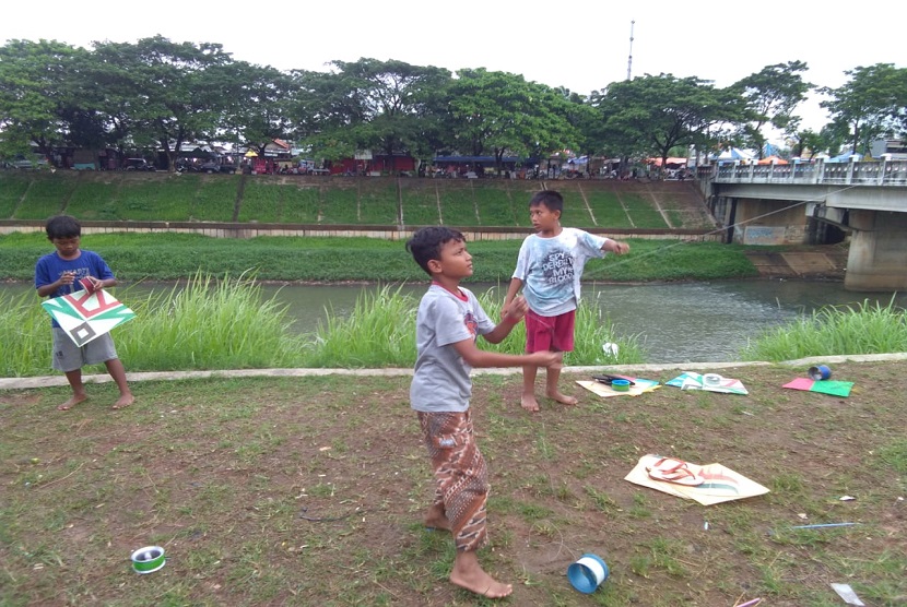 Anak-anak bermain layangan di sekitar kawasan Taman Banjir Kanal Timur, Duren Sawit, Jakarta Timur