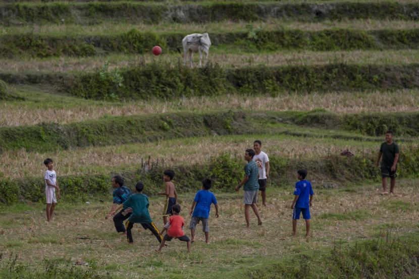 Anak-anak bermain sepak bola di lahan sawah yang belum diolah kembali setelah panen di Desa Porame, Sigi, Sulawesi Tengah, Selasa (7/6/2022). Orang tua perlu mengajarkan sportivitas dan rivalitas sehat dalam konteks kompetisi kepada anak-anaknya.