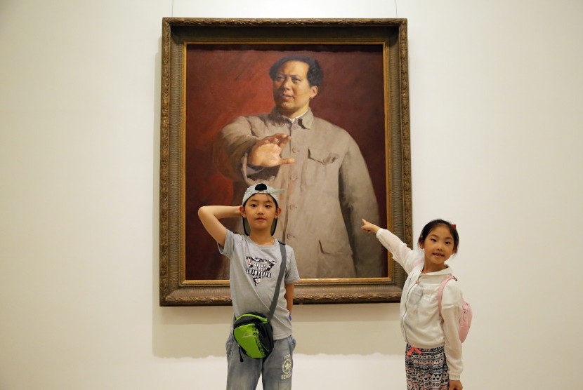 Anak-anak di Beijing, Cina, sedang berpose bersama lukisan mantan pemimpin Cina Mao Zedong.