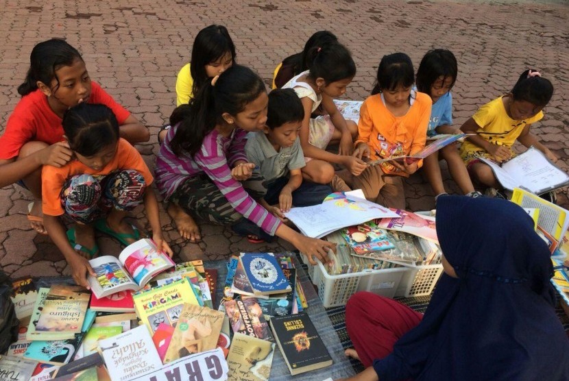 Anak-anak di Lapangan Atletik Cepu, Blora, Jawa Tengah, antusias meminjam dan membaca buku.