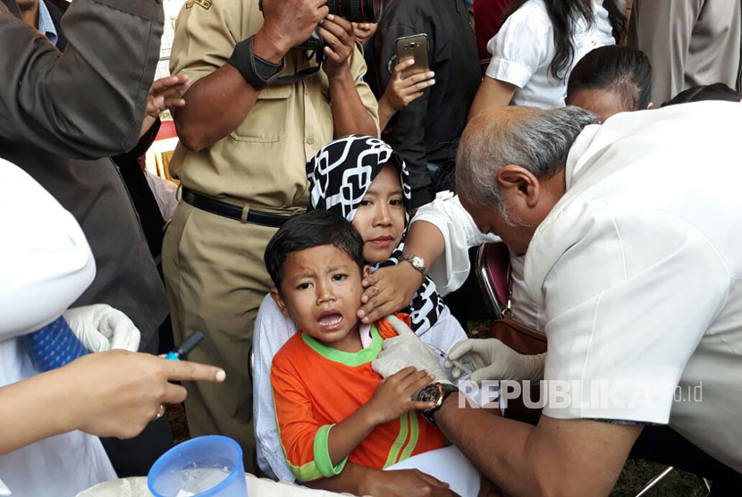 Anak-anak di Surabaya menjalani pemberian imunisasi Measles Rubella (MR) di Lapangan Putro Agung Kelurahan Karah, Surabaya, Selasa (1/8). 