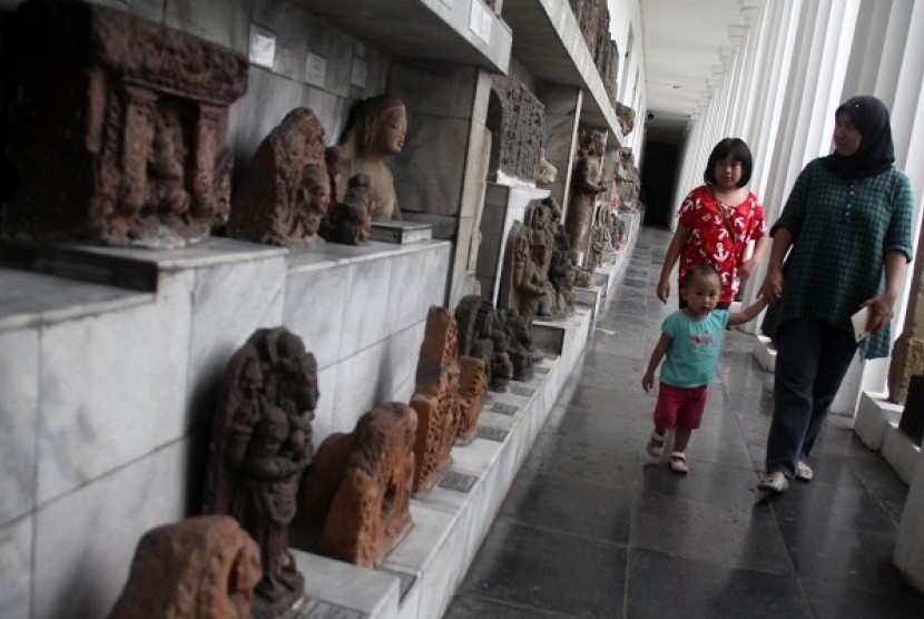 Anak-anak didampingi orang tuanya melihat sejarah relief dan patung di Museum Nasional Indonesia, Jakarta Pusat, Ahad (9/2).