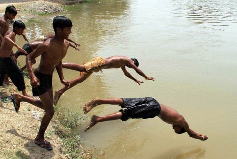 Anak-anak India bermain air di tengah gelombang panas.