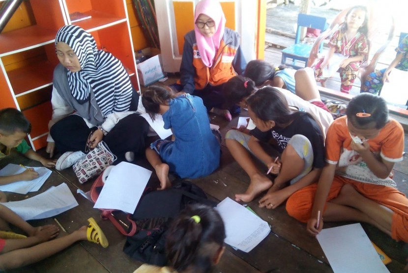 Anak-anak kampung nelayan Belawan belajar melukis dari mahasiswa Universitas Negeri Asahan (UNA) dan Komunitas Medan Menulis di Perpustakaan Terapung.