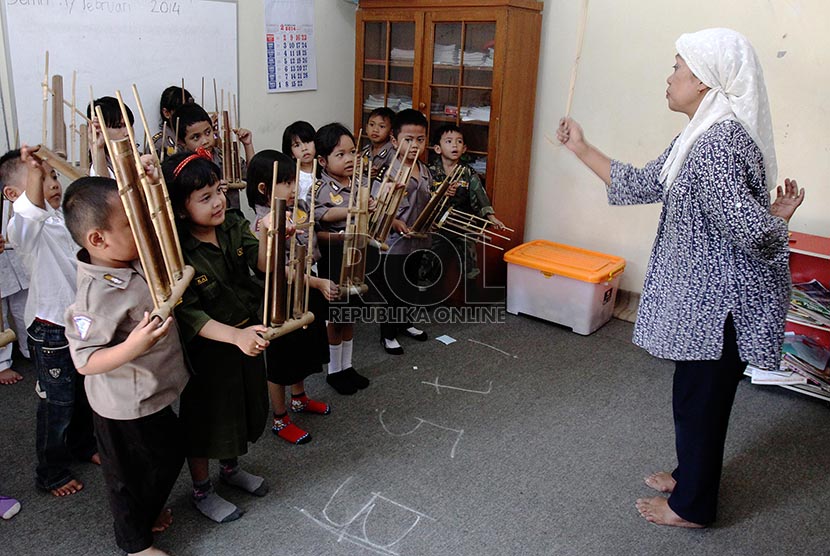 Anak-anak kelas B PAUD Mekar Gondangdia belajar bermain alat musik angklung, Jakarta Pusat, Kamis (20/2). 
