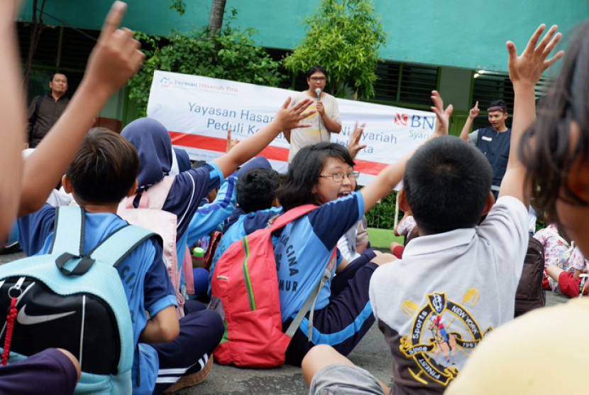 Anak-anak korban banjir di Kampung Bidara Cina, Kampung Melayu mendengarkan dongeng dari Dongeng Ceria.