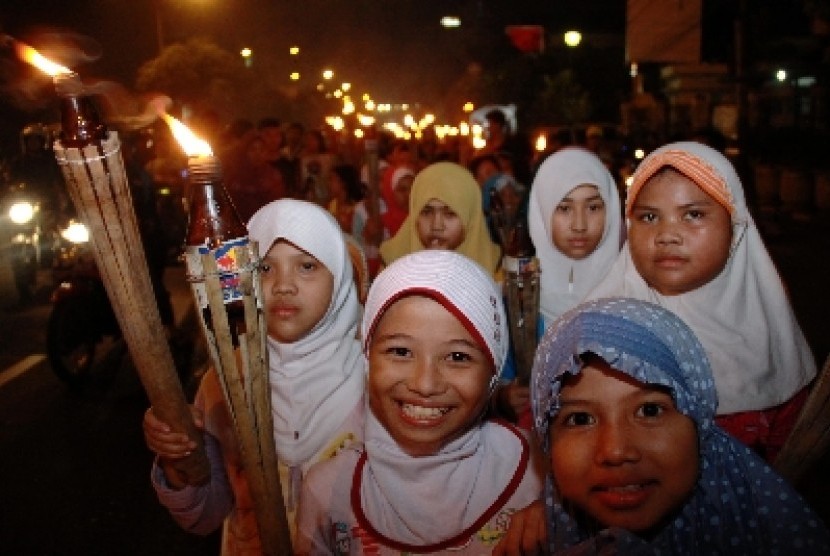 Anak-anak melakukan pawai obor saat malam takbir di Jalan Matraman, Jakarta Timur,Ahad (27/7). Pawai tersebut dalam rangka menyambut Hari Raya Idul Fitri 1 Syawal 1435 H dan tabuh beduk dan menyalakan kembang api sebagai hari kemenangan bagi umat Islam. 