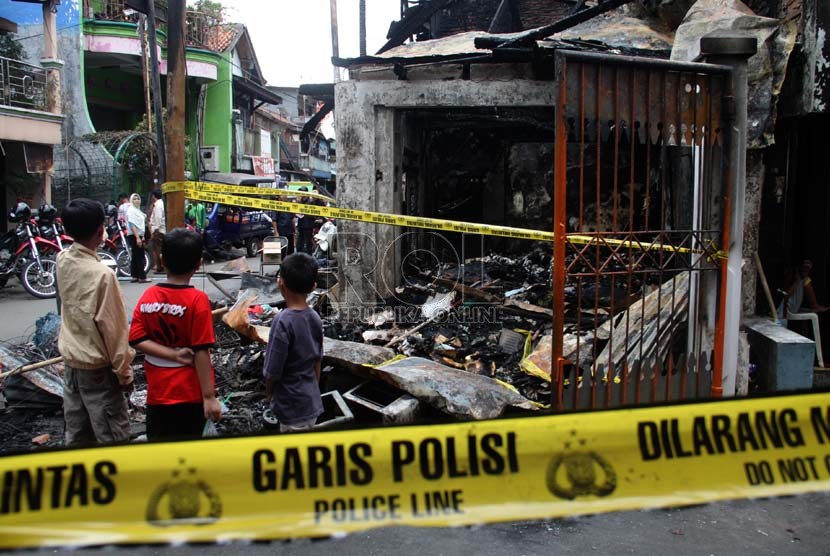 Anak-anak melihat bangunan yang terbakar akibat tawuran antarwarga di Johar Baru, Jakarta Pusat, Senin (18/11). (Republika/Yasin Habibi)