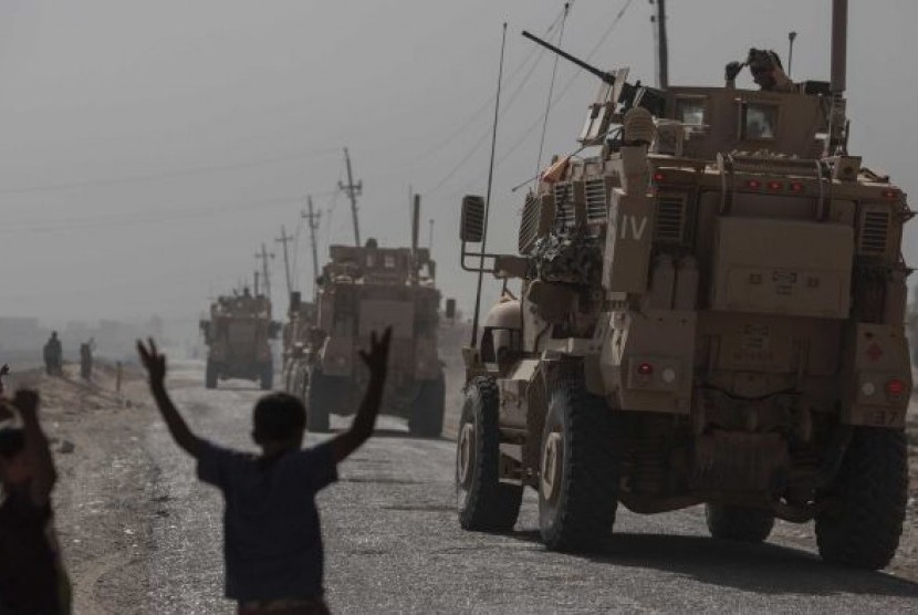 Anak-anak melihat iring-iringan kendaraan militer melewati desa Imam Gharbi, sekitar 70KM dari Mosul, Irak.