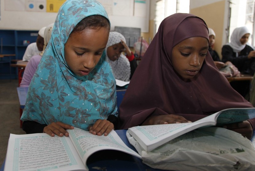  Anak-anak membaca Alquran selama bulan suci Ramadhan dalam sebuah madrasah di Nairobi, Kenya, Sabtu (21/7). (Sayyid Azim/AP)