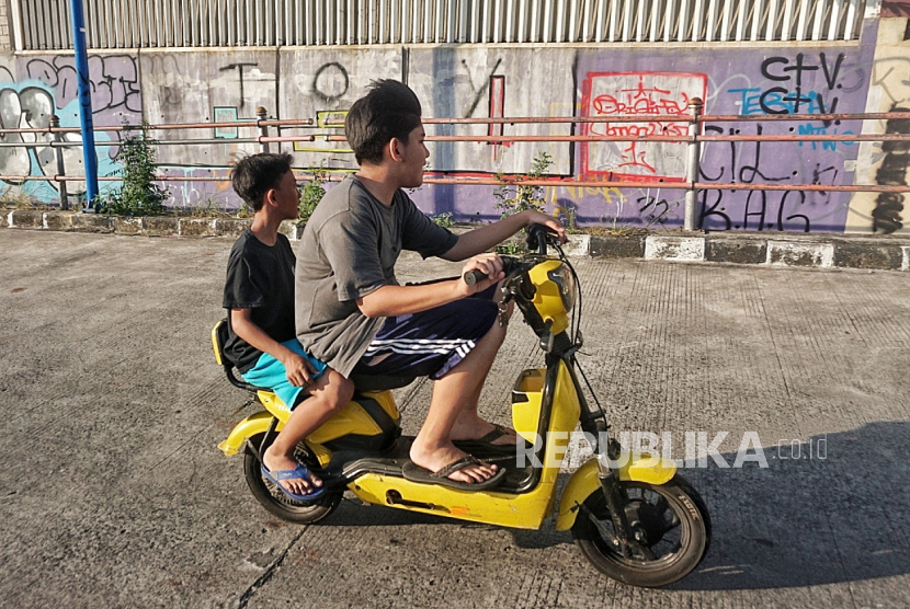 Anak-anak menaiki sepeda listrik di kawasan Jatinegara, Jakarta, Selasa (1/8/2023). Sepeda listrik mulai banyak dijumpai  seperti di kampung-kampung dan area kompleks. Sebagian besar sepeda listrik dinaiki oleh anak-anak karena tidak sedikit orang tua menganggapnya sebagai mainan.Tak jarang, mereka mengendarainya sambil ngebut dan bahkan masuk ke jalan umum. Berdasarkan dalam Peraturan Menteri Perhubungan No 45 Tahun 2020 tentang Kendaraan Tertentu dengan Menggunakan Penggerak Motor Listrik, sebenarnya sudah diatur jika usia minimal pengendara sepeda listrik adalah 12 tahun. Untuk pengendara usia 12-15 tahun, tetap harus didampingi oleh orang dewasa.