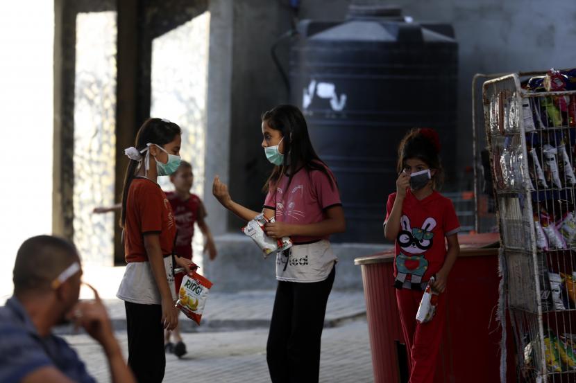 Anak-anak mengenakan masker wajah saat berbelanja di toko bahan makanan selama penguncian yang diberlakukan selama pandemi virus corona, di kamp pengungsi Shati, di Kota Gaza, Kamis, 27 Agustus 2020. Ilustrasi.