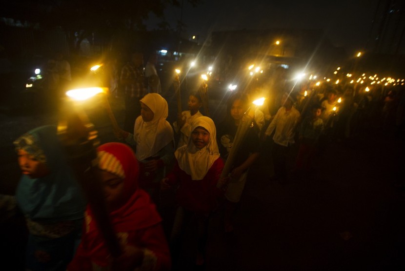 Anak-anak mengikuti pawai obor pada malam takbiran di kawasan Matraman, Jakarta, Ahad (27/7). 