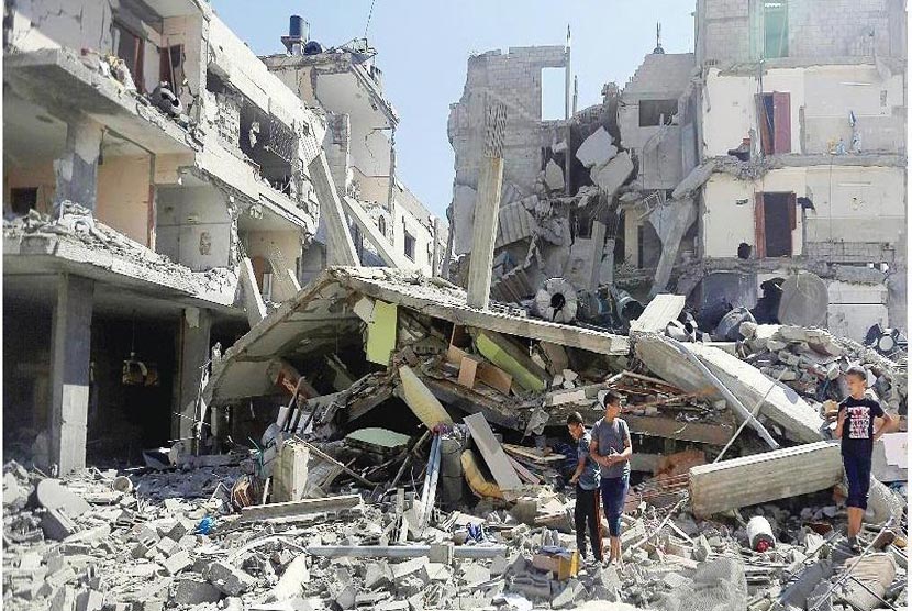 Anak-anak Palestina bermain di reruntuhan bangunan yang hancur akibat bombardir serangan udara Israel,Jumat (11/7).