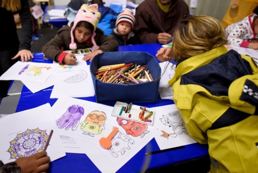Anak-anak pengungsi imigran mewarnai di kamp pengungsian Celle, Jerman.