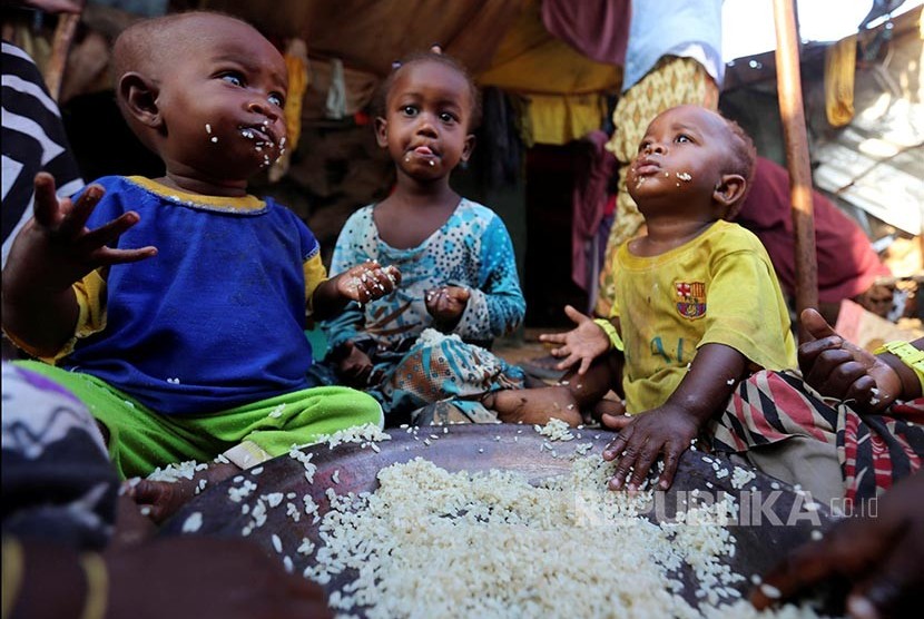 Anak-anak pengungsi menyantap nasi tanpa lauk di kamp pengungsian Al Cadaala, Mogadishu, Somalia.